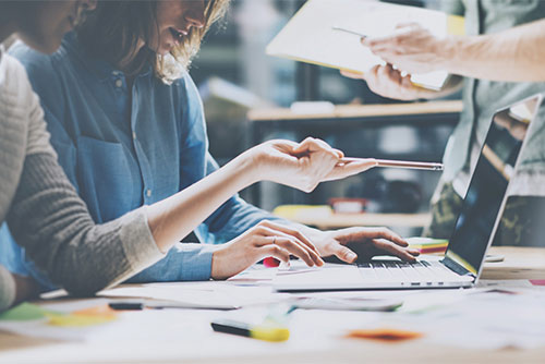 Persone che lavorano insieme davanti a un computer portatile
